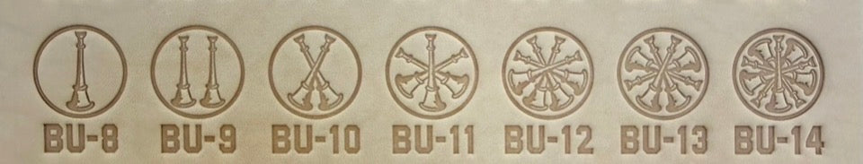 Group of seven delrin leather stamps showing firefighter bugle rank insignia.