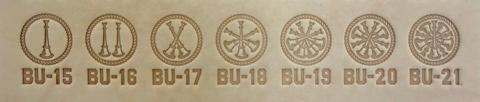Group of seven delrin leather stamps showing firefighter bugle rank insignia.