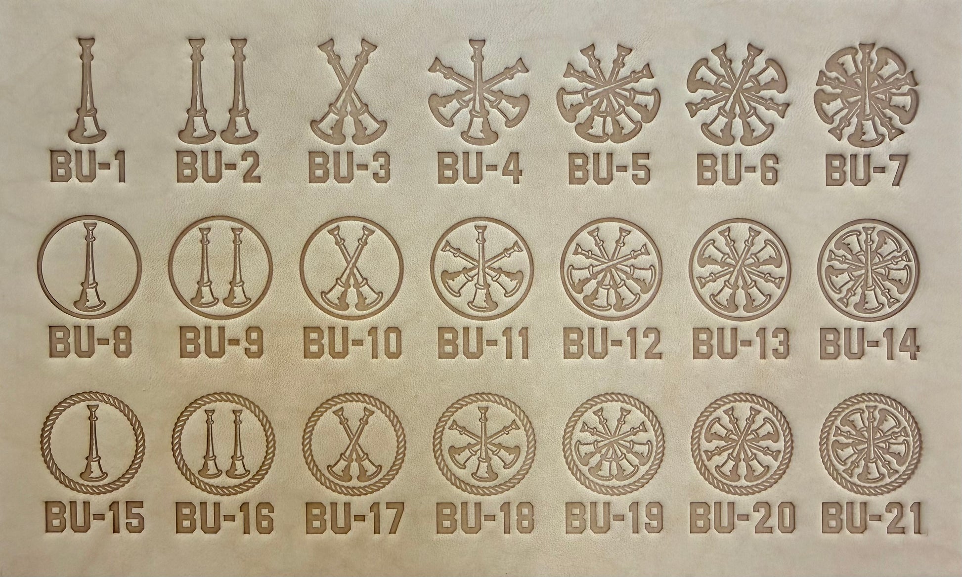 Group of twenty-one Delrin leather stamps showing firefighter bugle rank insignias.