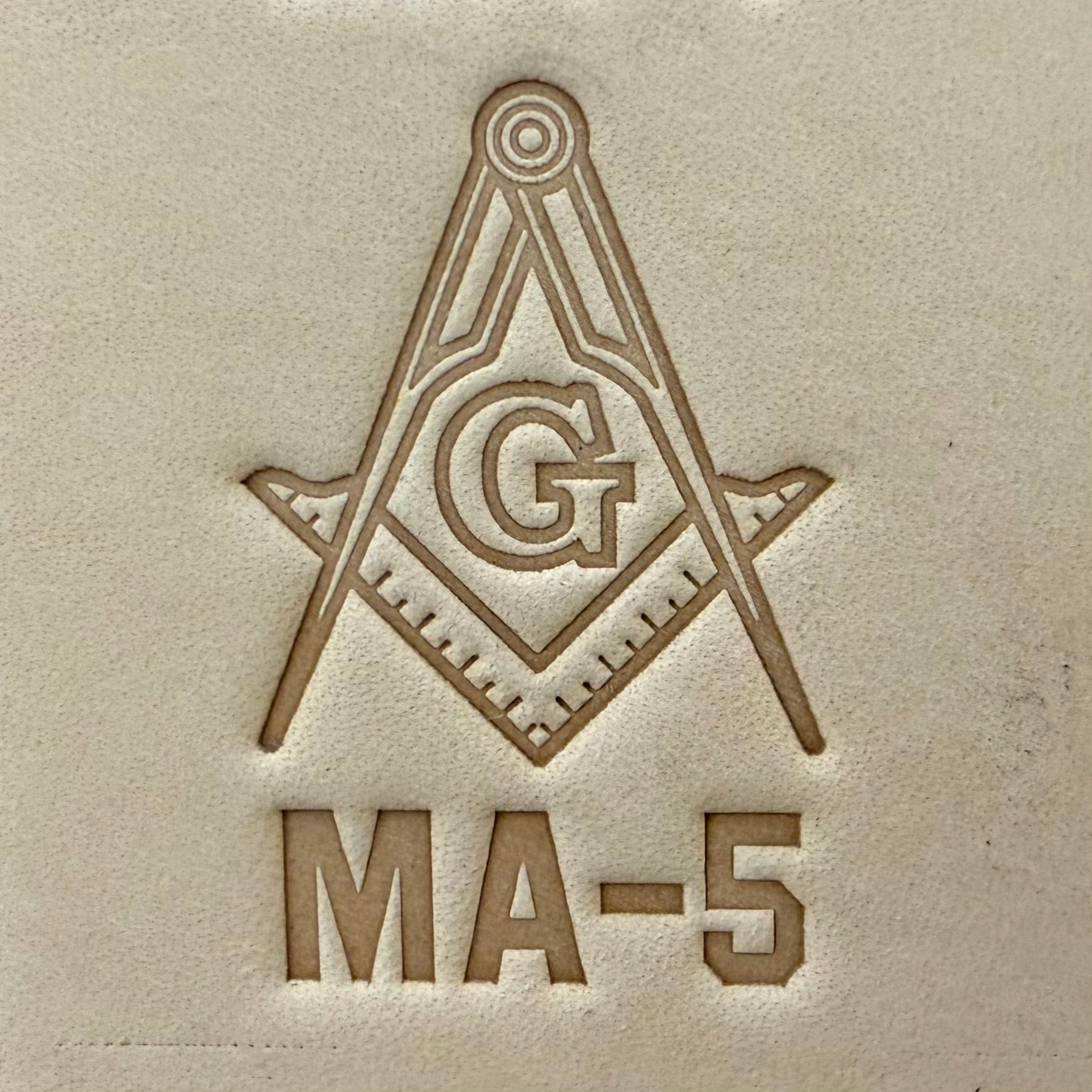 Embossing stamp featuring a Masonic square and compass emblem with the letter G.