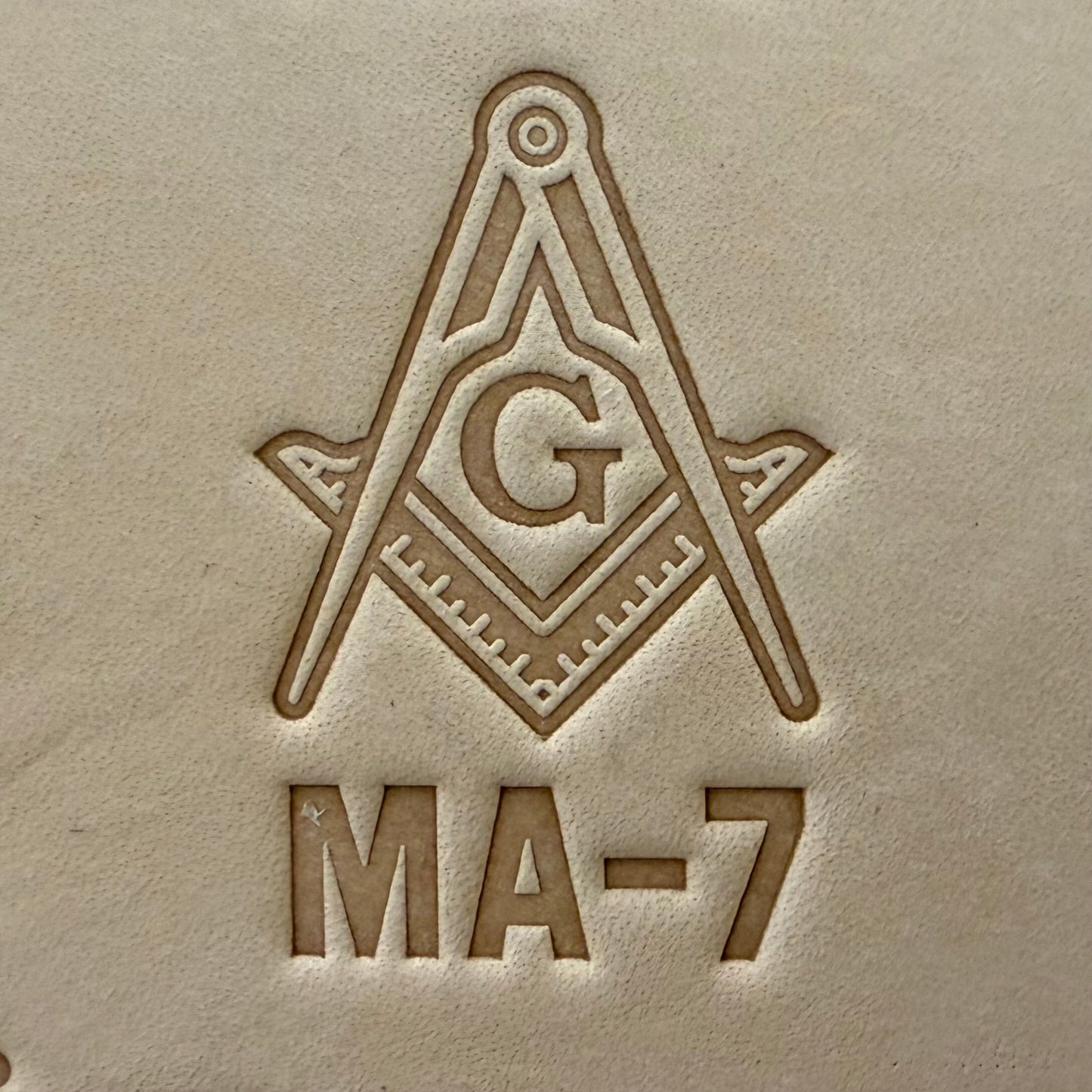Embossing stamp featuring a Masonic square and compass emblem with the letter G.