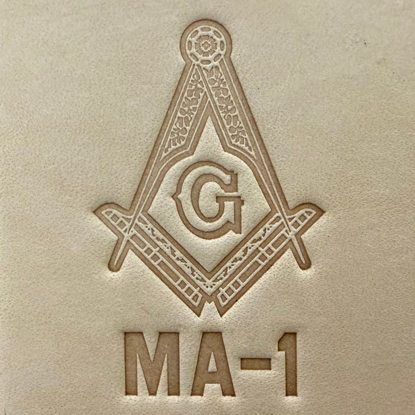 Embossing stamp featuring a Masonic square and compass emblem with the letter G.