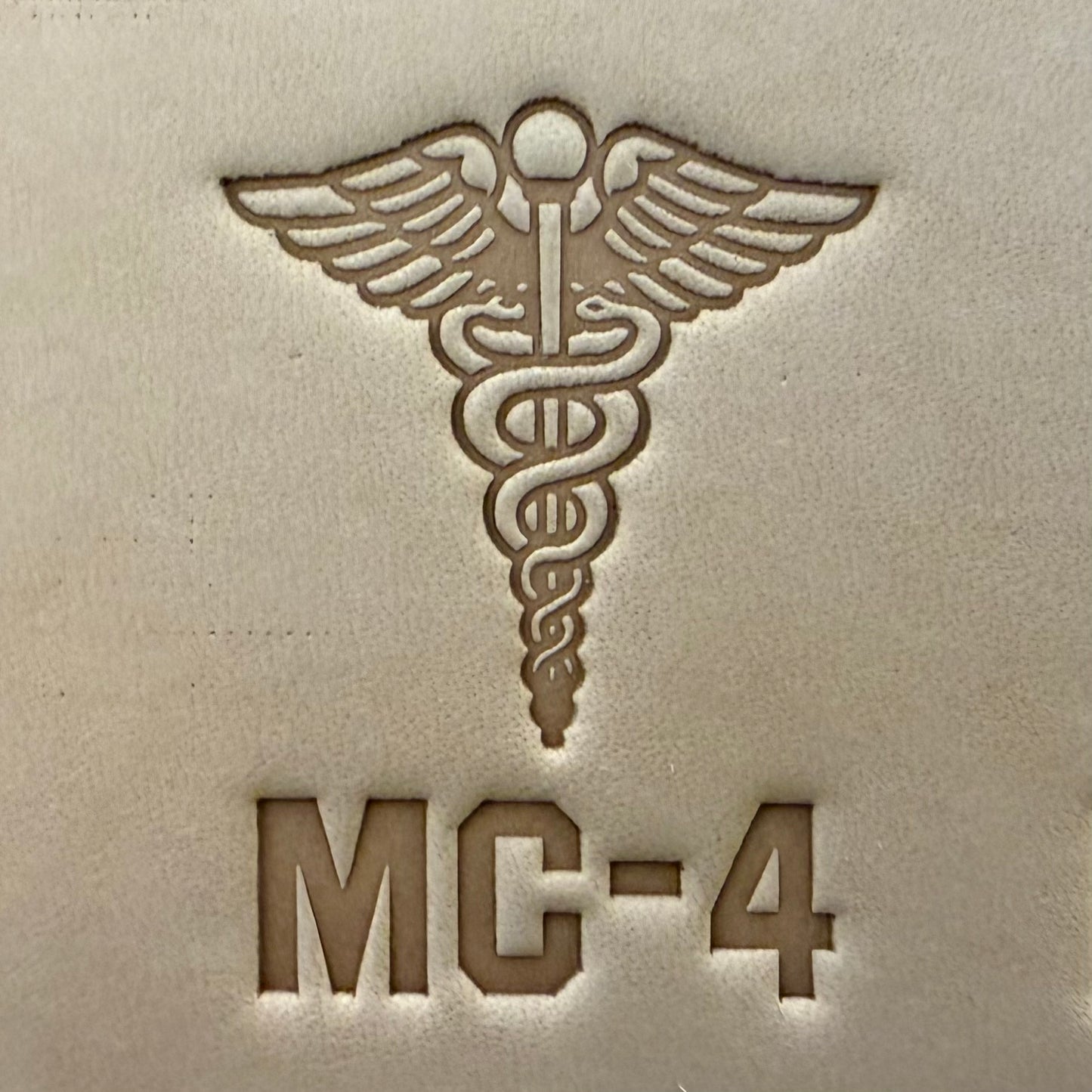 Leathercrafting impression of a medical caduceus symbol.