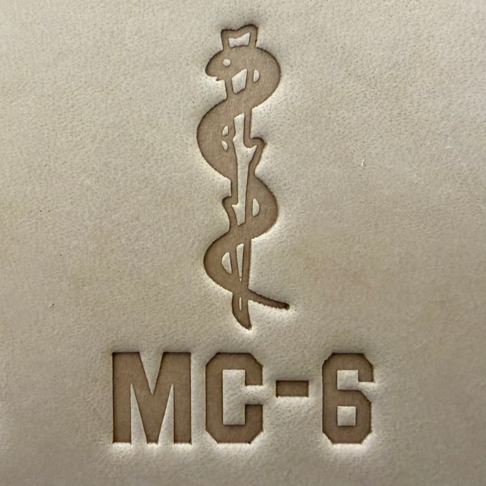 Leathercrafting impression of a medical caduceus symbol.