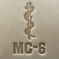Leathercrafting impression of a medical caduceus symbol.